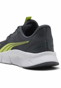 Grauer Sportschuh mit Mesh-Obermaterial, gelbem Akzentstreifen, gepolstertem Kragen und weißer Mittelsohle mit strukturiertem Design.