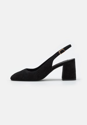 Czarny zamszowy but typu slingback na obcasie blokowym z złotym paskiem i klamrą, prezentowany na białym tle.