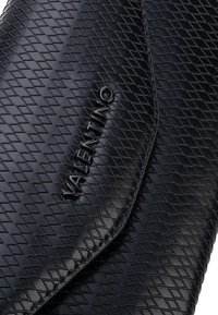 Pochette en cuir noir, dotée d'un motif en losanges texturé, d'un logo "Valentino" embossé, et d'une fermeture à rabat élégante.