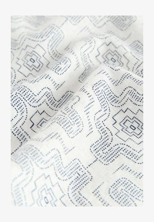 Tela blanca con un patrón geométrico azul que presenta líneas y formas onduladas. La textura parece suave con un ligero brillo.