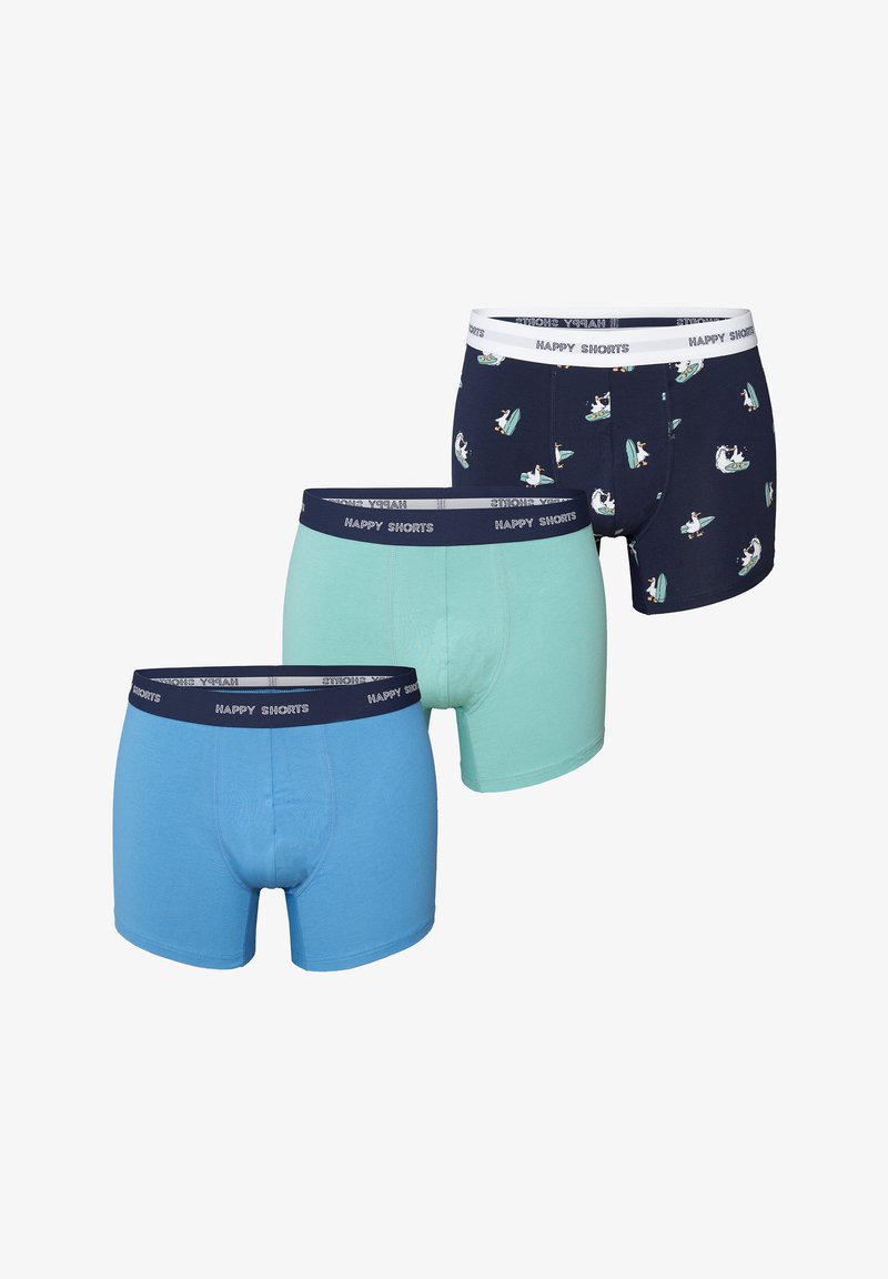 Drie paar herenboxershorts: lichtblauw, mintgroen en marineblauw met een surferpatroon. Allemaal voorzien van elastische taillebanden met de tekst "HAPPY SHORTS".