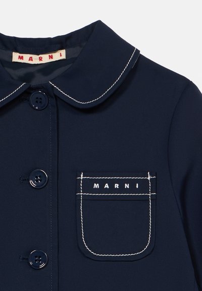 Μπλε ναυτικό παλτό με στρογγυλεμένη γιακά, μπροστά με τέσσερα κουμπιά και τσέπη στο αριστερό μέρος του στήθους με λευκή ραφή και το όνομα της μάρκας "MARNI".
