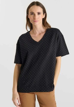 T-shirt nera a scollo a V con piccoli punti bianchi in un motivo ripetuto. Maniche corte e vestibilità comoda con una texture liscia.