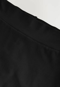 Zwarte stof, hoge taille rok met een gladde textuur. Uitgerust met een verborgen rits aan de achterkant en contrasterende naden.