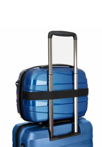 Kleine blauwe koffer vastgemaakt op een grotere blauwe koffer met een uitgeschoven telescopische handgreep en een zwarte band.