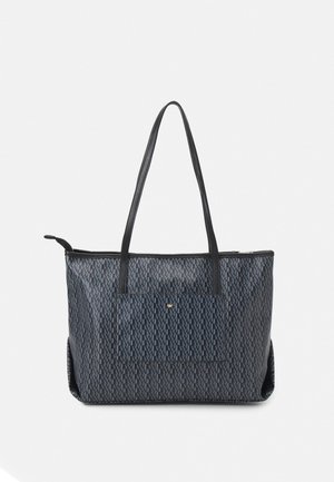 Grand sac cabas noir avec motif texturé, deux longues anses et une poche avant, présenté sur un fond blanc uni.