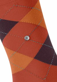 Chaussette à motif argyle en orange, rouille et violet avec une couture turquoise et un petit bouton en métal portant l'inscription "Burlington The Original."