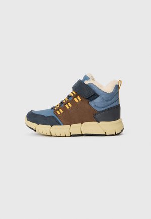 Hoge sneaker in lichtblauw en bruin, met een fuzzy binnenkant. Beschikt over gele accenten, een verstelbare band en een gestructureerde rubberen zool.