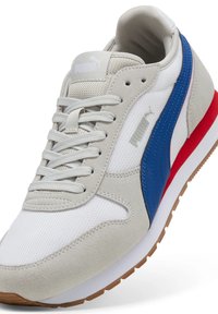 Graue und weiße Puma-Sneaker mit blauen Streifen, rotem Akzent an der Sohle, weißen Schnürsenkeln und Gummisohle, im Winkel gezeigt, um obere und seitliche Details zu zeigen.