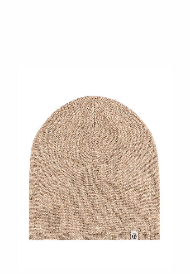 Beige knitted beanie hat with a smooth texture, tapered top, and a small logo patch on the bottom edge.