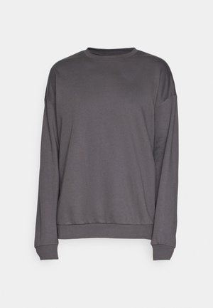 Sweatshirt gris à manches longues en tissu doux. Il présente un col rond et des poignets côtelés. Design simple sans motifs ni accents.