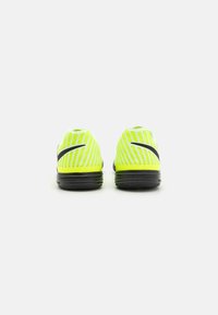 Dzelteni Nike sporta apavi ar sietveida augšdaļu un diagonālām svītrām, noapaļotu papēdi un melnu zoli, kas nodrošina saķeri un stabilitāti.