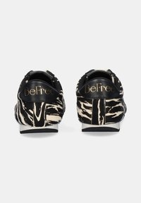 Zapatillas con estampado de cebra en blanco y negro, con un acabado de piel de textura, que presentan detalles en cuero negro y la marca dorada "BeFree" en el talón.