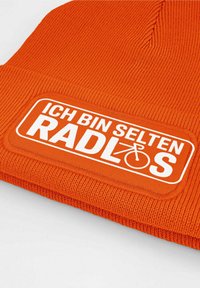 Orange knitted beanie with a wide white patch. Text reads "ICH BIN SELTEN RADLÖS." Features ribbed texture and fitted design.