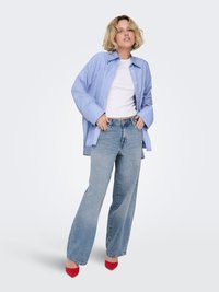 Ljusblå randig oversized skjorta, vit figursydd t-shirt, ljusblå jeans med hög midja och röda spetsiga klackskor.