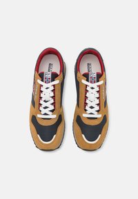 Sneaker marroni e neri con accenti rossi, caratterizzati da un mix di materiali in suede e mesh, lacci bianchi e una suola in gomma texturizzata.