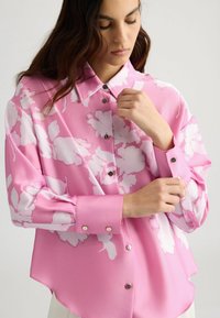 Roze bloemen blouse van lichtgewicht stof, met een kraag, knoopsluiting aan de voorkant en langwerpige mouwen met knoopmanchetten.