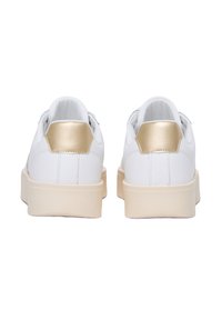 White sneakers with a gold accent at the heel, smooth material, rounded shape, and thick cream-colored sole. Clean design with no visible patterns.