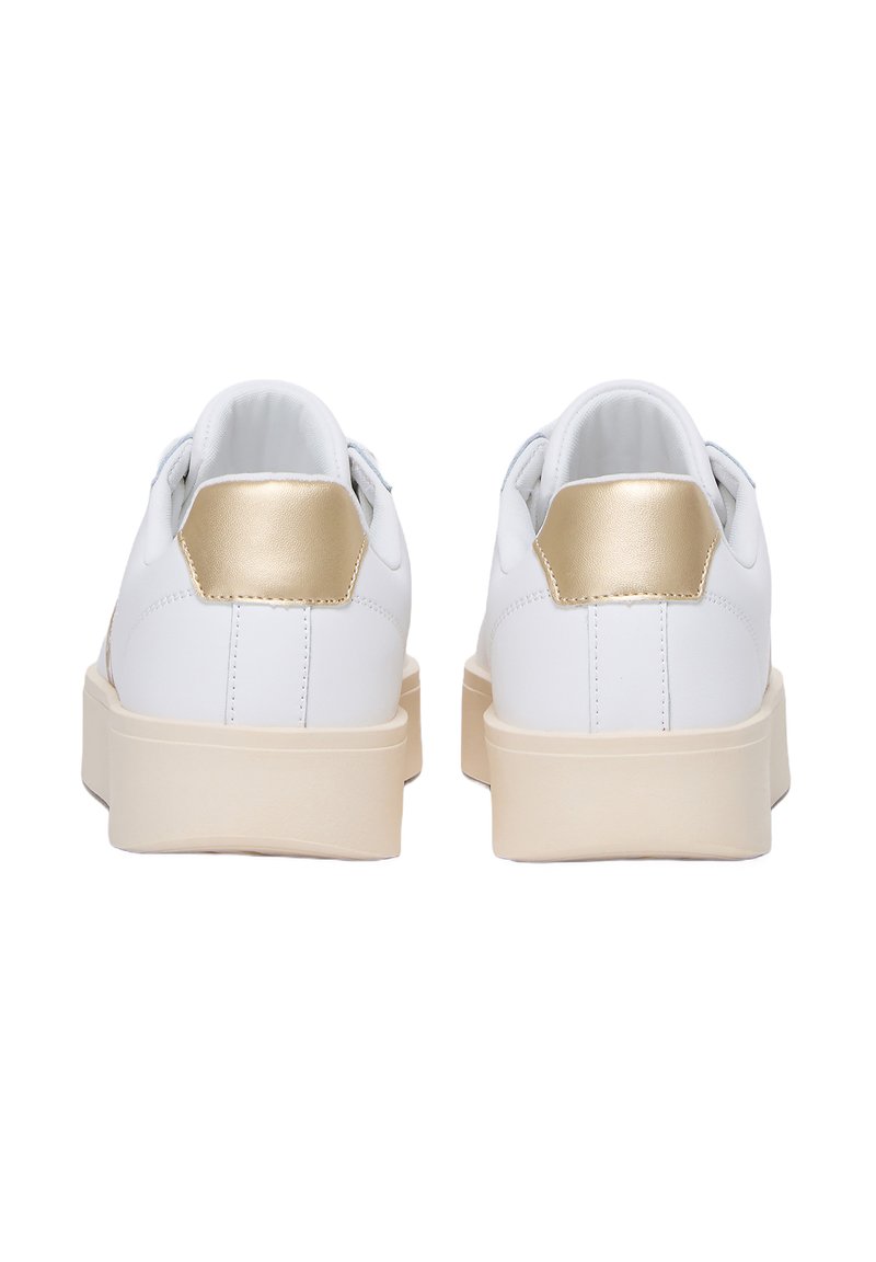 Zapatillas blancas con un acento dorado en el talón, material suave, forma redondeada y suela gruesa de color crema. Diseño limpio sin patrones visibles.