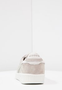 Grau Wildleder Sneaker mit weißem Gummisohle und Fersenlasche. Verfügt über ein geprägtes Logo an der Ferse und ein strukturiertes Seitenpaneel.