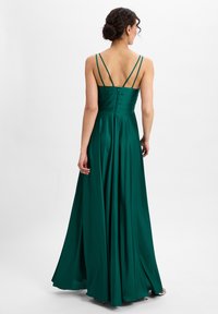 Langes, smaragdgrünes Satin-Kleid mit einem taillierten Oberteil und fließendem Rock. Verfügt über schmale Träger und eine geknöpfte Rückendetails.