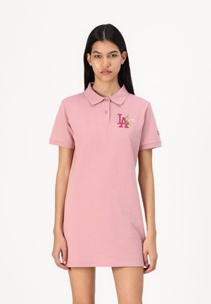 Roze polo haljina s kratkim rukavima i ovratnikom. Ima izvezeni logotip "LA" i cvjetni uzorak na prsima. Mekani, glatki pamučni materijal.