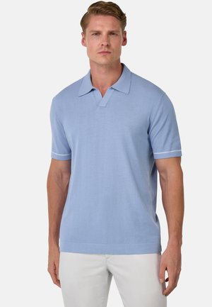 Polo shirt azzurro chiaro a maniche corte con colletto flat, caratterizzato da un scollo a V e righe bianche a contrasto sulle maniche. Tessuto morbido a maglia.