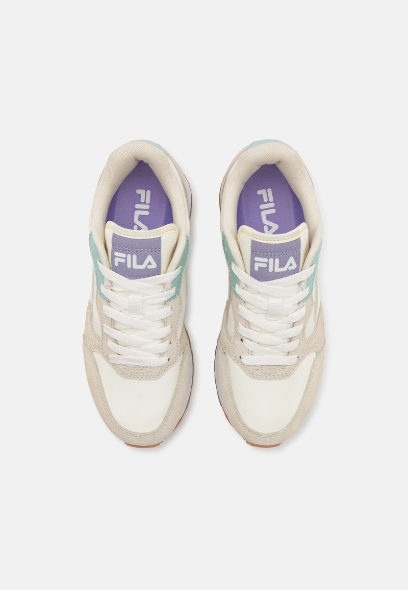 Sneakers Fila con una toma in pelle bianca, accenti in suede beige, pannelli laterali azzurri e una soletta viola con il logo.