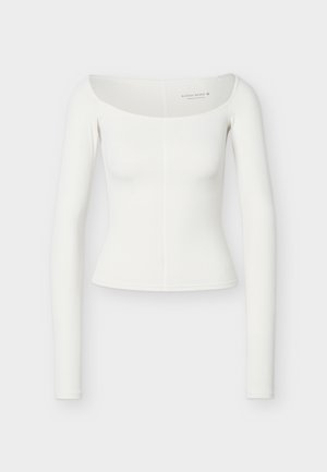 Hvid langærmet tætsiddende top med bred bådudskæring og subtil lodret søm ned foran i midten, ensfarvet jævnt stof.