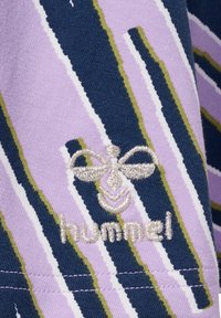 Lilac en marineblauw gestreepte stof met een geborduurd bijlogo en de tekst "hummel" in zilver, met een gladde textuur.
