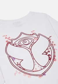 Witte katoenen t-shirt met een centraal rood en roze bloemenpatroon met een vlinderontwerp, versierd met pailletten en complexe lijnen.