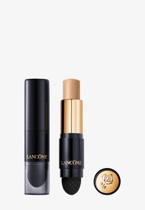 Podkład w sztyfcie Lancôme w czarnej tubie z złotym akcentem. Aplikator z miękkim włosiem. Zawiera okrągłą złotą zakrętkę.