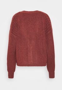 Ribbad stickad tröja i mörkröd. Har en rundad halsringning och långa ärmar. Mjuk textur med elastiska mudd och nederkant, designad för en avslappnad passform.