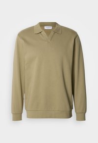 Pull beige à manches longues avec col polo, poignets et bas-côtes, présenté sur fond blanc.
