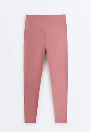 Højtaljede, tætsiddende leggings i mauve med glat stof uden synlige lommer eller mønstre, vist mod en ensfarvet hvid baggrund.