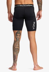 Schwarze elastische Boardshorts mit einem breiten, markierten Bund, schlanker Passform und subtilen Taschenlinien an der Seite.
