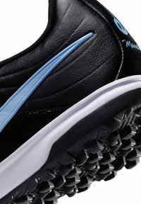 Zwarte sportschoen met een gestructureerde zool, lichtblauwe swoosh-logo aan de zijkant, witte tussenzool en ademend synthetisch bovenmateriaal.