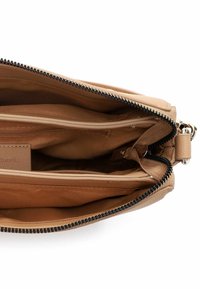 Torebka ze skóry o kolorze koniakowym, z zamkiem błyskawicznym, dwoma wewnętrznymi przegrodami i gładką fakturą. Czarny zamek z metalowymi ozdobami.
