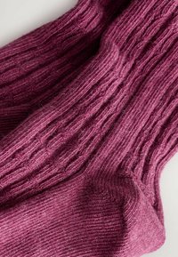 Rippensocken in tiefem Burgunderrot, aus weichem Wollmix gefertigt. Sie verfügen über ein strukturiertes Muster und eine verstärkte Zehenpartie für zusätzliche Haltbarkeit.