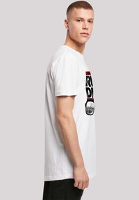 White cotton t-shirt featuring a large black and red graphic print with a design resembling sunglasses on the front. Short sleeves, crew neck.