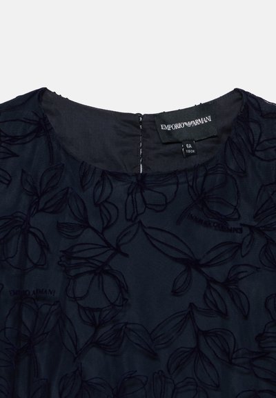 Haut de robe en tissu noir transparent avec motifs de feuilles brodés et étiquette Emporio Armani visible près de l'encolure et de l'étiquette de taille.