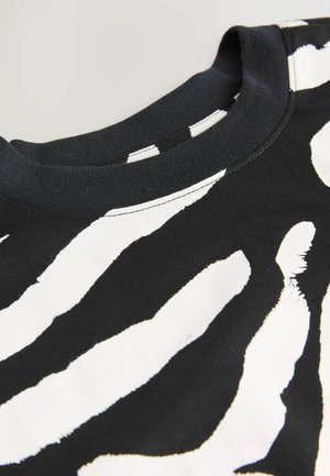 Schwarzes T-Shirt mit einem auffälligen weißen Zebrastrichmuster, rundem Halsausschnitt, kurzen Ärmeln und einer weichen Baumwollstofftextur.