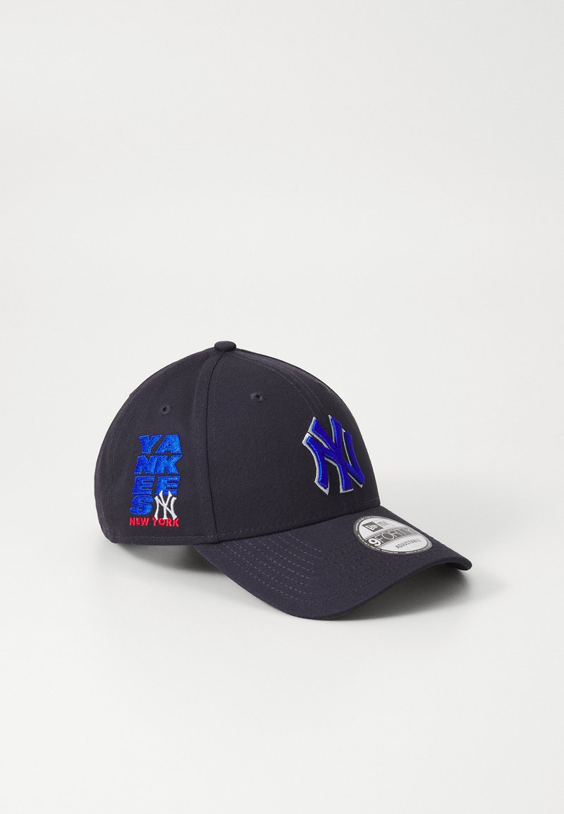Căciulă marină din țesătură, cu un logo brodat al echipei New York Yankees în albastru închis. Pe lateral se află cuvântul "YANKEES" brodat în albastru și roșu.