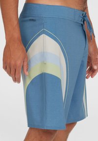 Blaue Badeshorts mit einem mehrfarbigen Wellenmuster, aus einem strukturierten Stoff gefertigt, mit einem Kordelzugbund und Logodetails.