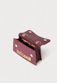 Mala mare krvljenih tonova s otvorenim preklopom, zlatnim lancem na petljama i zlatnim natpisom "Just Cavalli" sprijeda, s unutrašnjim korištenjem uzorka leoparda.