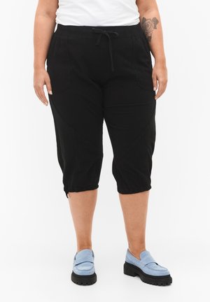 Black cropped pants with an elastic waistband and drawstring. Features side pockets and a relaxed fit with gathered hems for added texture.