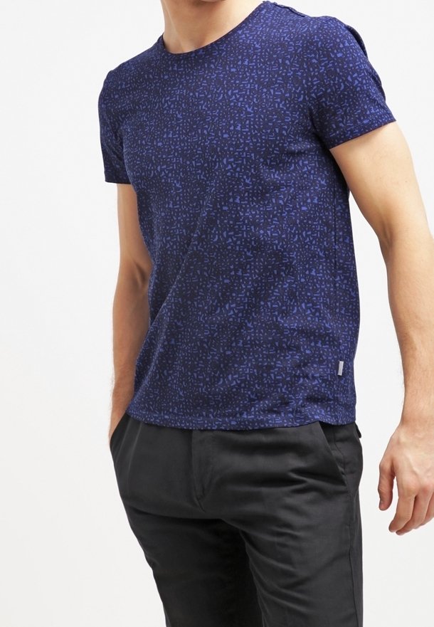 Camiseta de manga corta en azul marino con un patrón geométrico. Hecha de una tela texturizada, presenta un cuello redondo y una pequeña etiqueta de logo en el dobladillo.