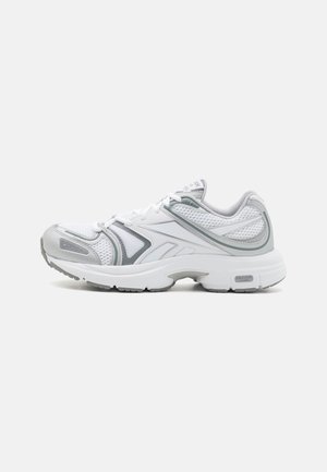 Zapatillas deportivas de malla blanca con acentos grises, sobrecapas texturizadas y una suela acolchada. Presentan cordones y un diseño con punta redonda.