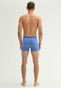 Kék pamut boxer alsó fekete márkás derékrésszel, testhezálló fazonban és sima textúrával, hátulról bemutatva, semleges háttéren.