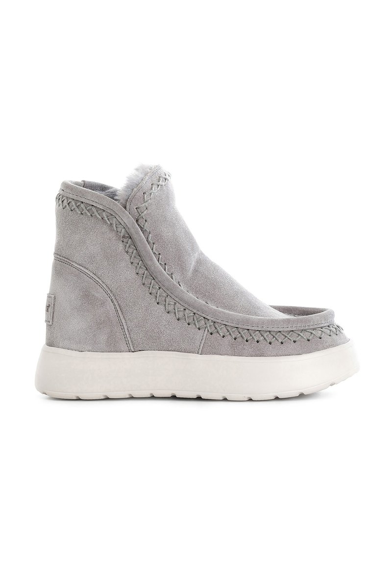 Botas de tobillo de ante gris con un forro suave, detalles de costura a lo largo de los bordes y una suela de goma blanca. Punta redondeada con parte delantera abierta.